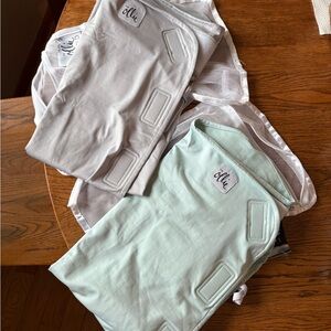 TWO brand new Ollie Swaddles. Blue and grey.